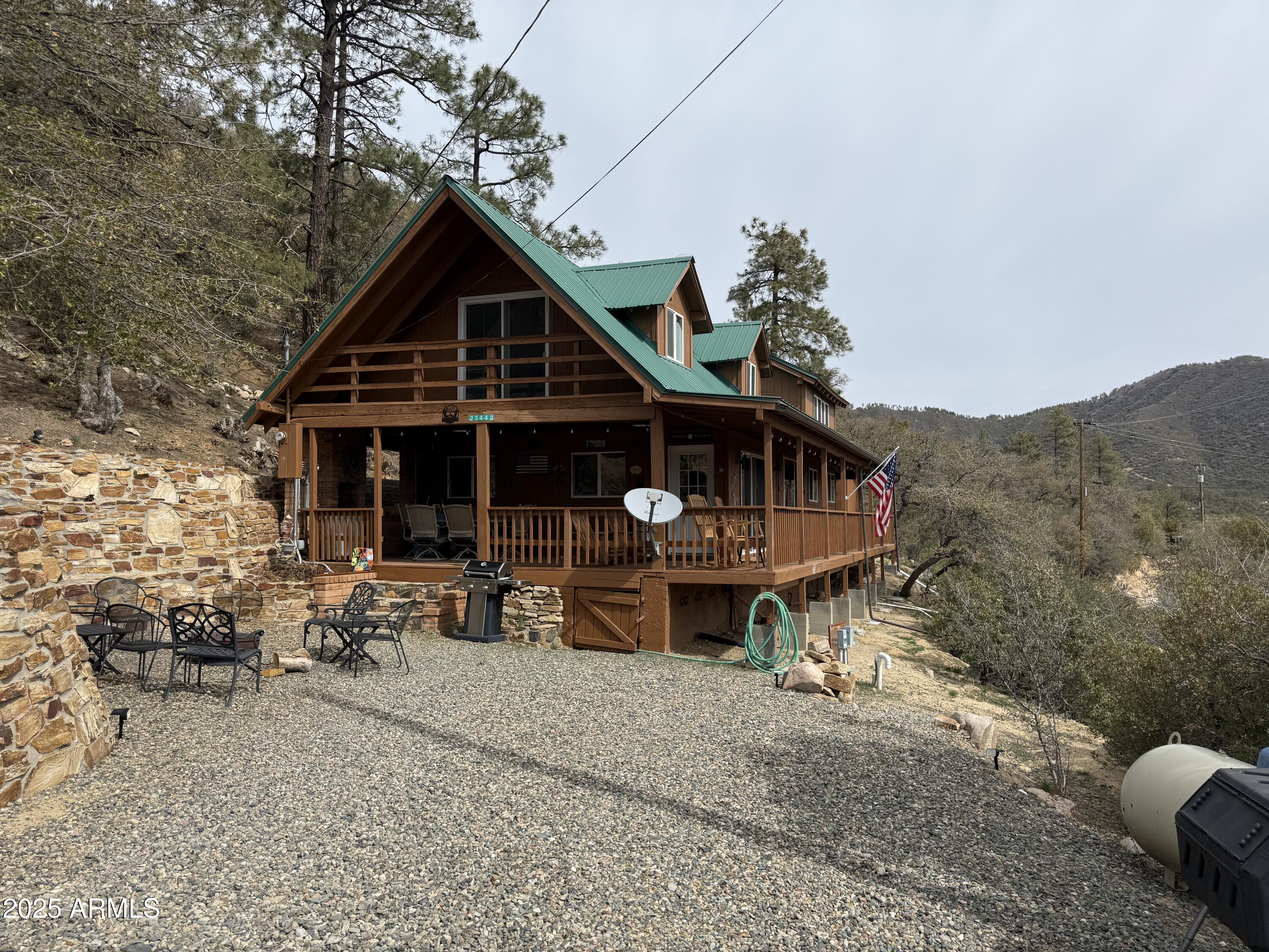 23442 Manzanita Road Crown King, AZ 86343 - Photo 1 of 41 a view of a house with wooden deck and furniture