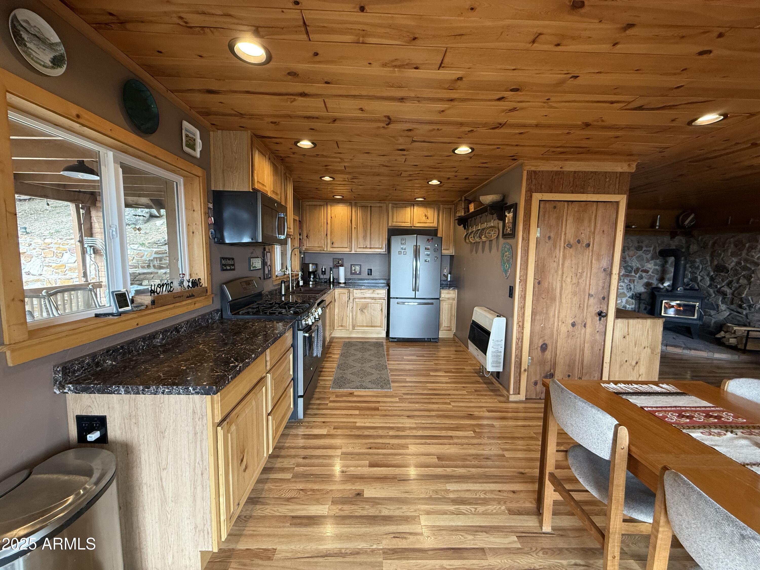 23442 Manzanita Road Crown King, AZ 86343 - Photo 31 of 41 a large kitchen with stainless steel appliances kitchen island granite countertop a large counter top and a stove