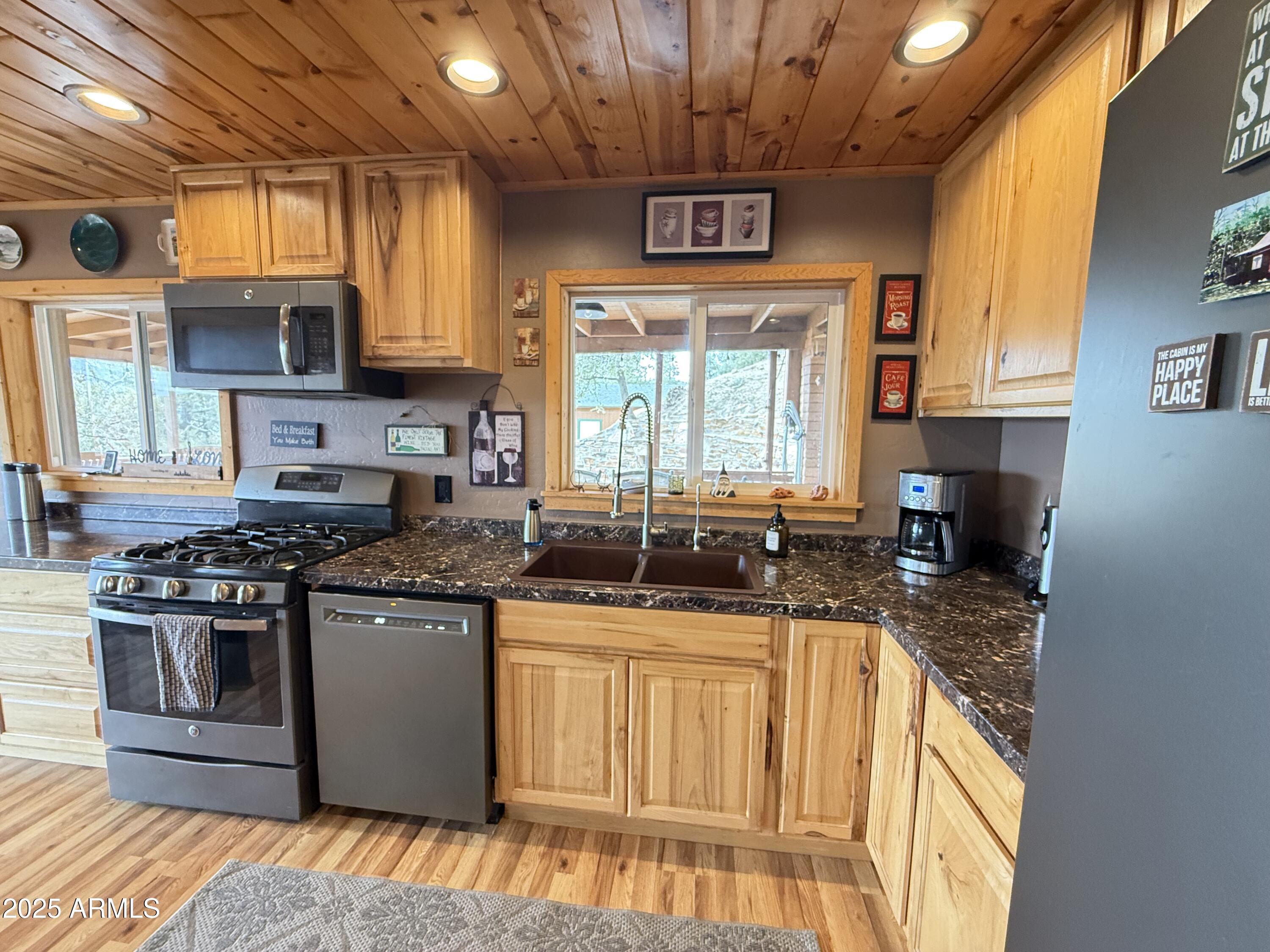 23442 Manzanita Road Crown King, AZ 86343 - Photo 5 of 41 a kitchen with stainless steel appliances granite countertop a stove a sink and a microwave