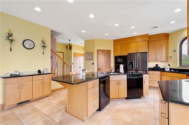 a large kitchen with stainless steel appliances lots of counter space and breakfast area