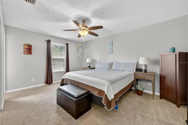 a spacious bedroom with a bed and a chandelier