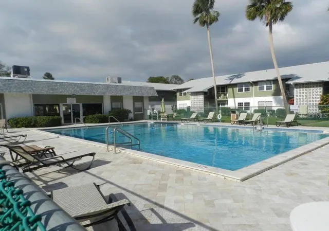 a view of a house with pool and a yard