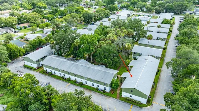 an aerial view of residential houses with outdoor space and trees