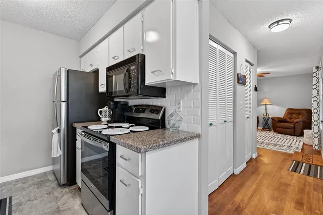 a kitchen with stainless steel appliances granite countertop a refrigerator stove and sink