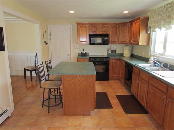 52 Vista Circle Rutland, MA 01543 - Photo 7 of 30 a kitchen with stainless steel appliances a sink a stove a microwave a dining table and chairs