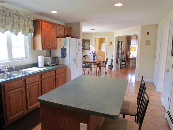 52 Vista Circle Rutland, MA 01543 - Photo 9 of 30 a kitchen with stainless steel appliances granite countertop a table chairs sink and white cabinets
