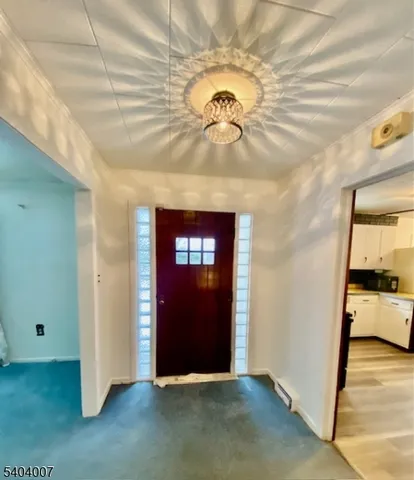 an empty room with a chandelier fan and wooden floor