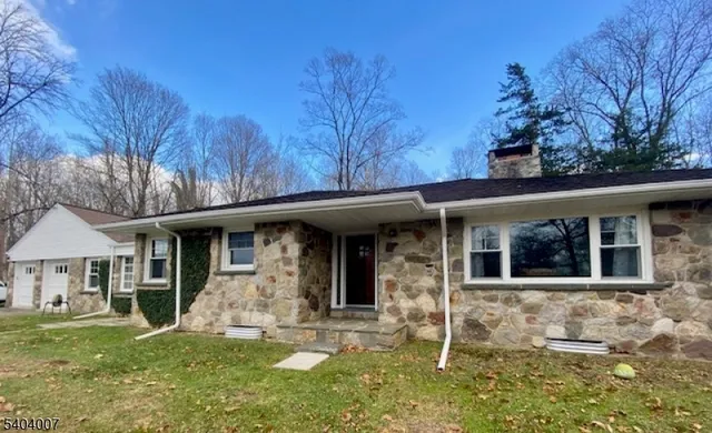 a front view of a house with yard and tree s
