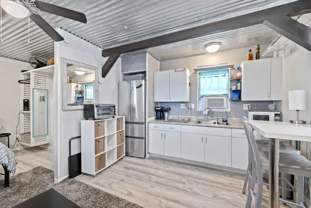 a kitchen with stainless steel appliances kitchen island granite countertop a refrigerator and cabinets