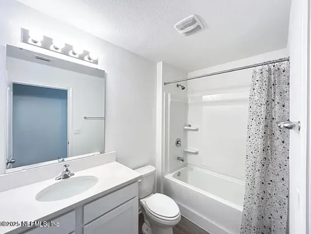 a bathroom with a sink a toilet a mirror a bathtub and shower