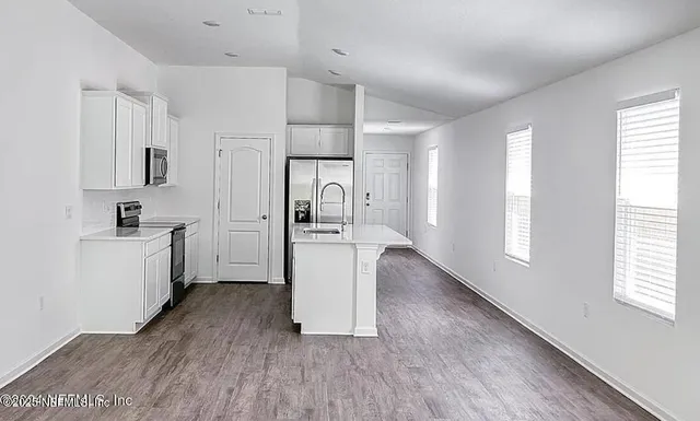 a kitchen with white cabinets and stainless steel appliances