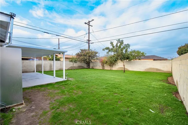 a view of a backyard with plants and a bench