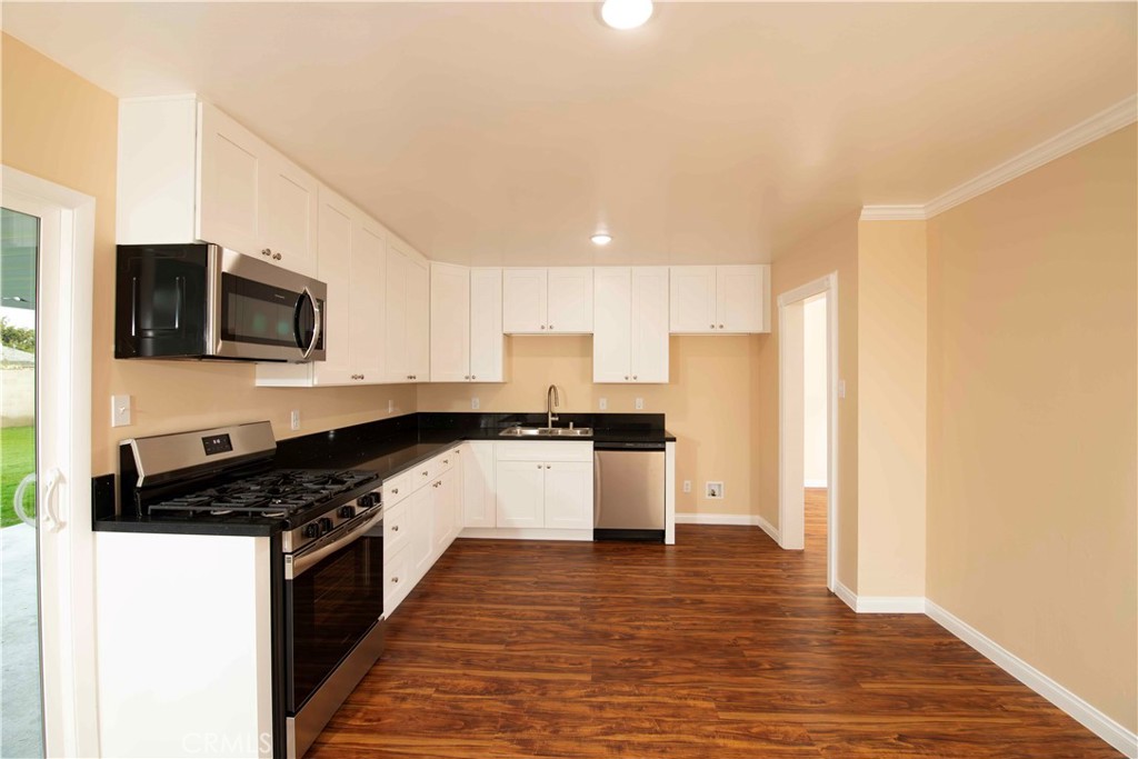 22729 Marbella Avenue Carson, CA 90745 - Photo 40 of 57 a kitchen with granite countertop a stove top oven a sink a counter space and cabinets