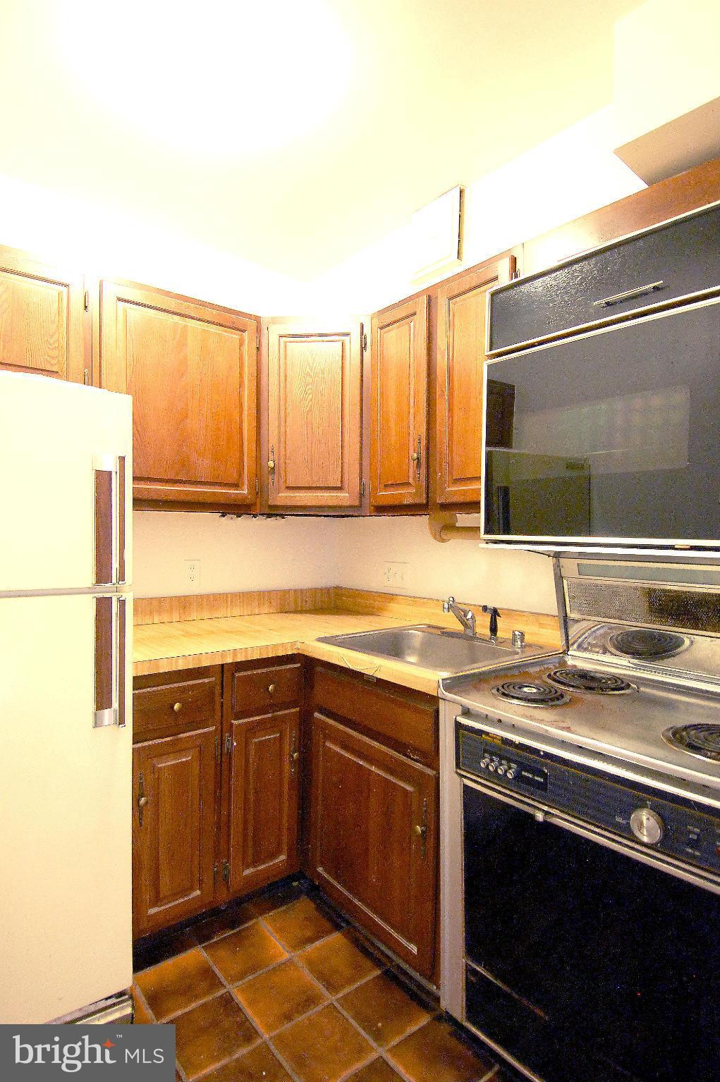 4000 Beecher Street Northwest, Unit 101 Washington, DC 20007 - Photo 7 of 26 a kitchen with a sink stove and microwave