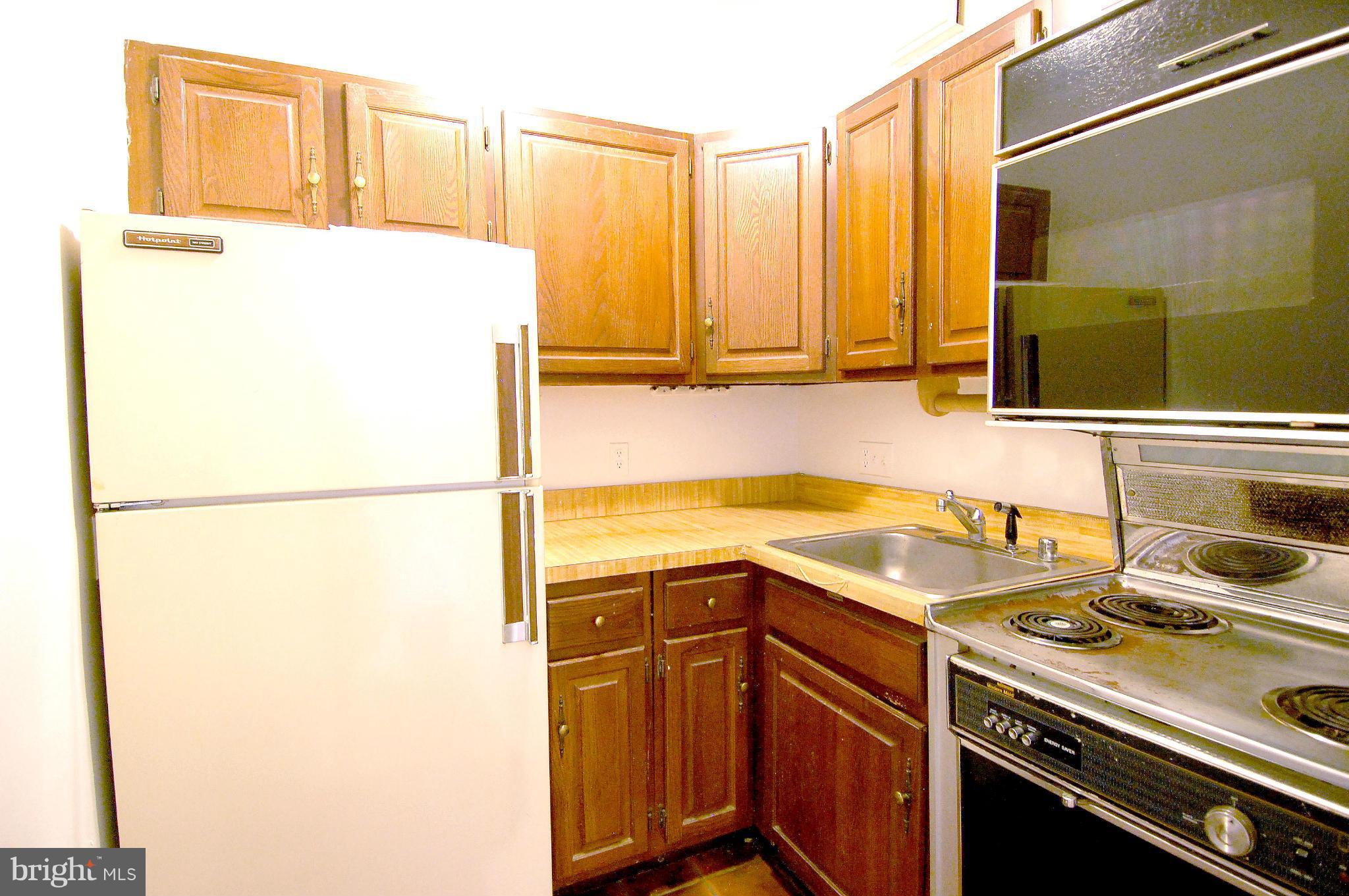 4000 Beecher Street Northwest, Unit 101 Washington, DC 20007 - Photo 8 of 26 a kitchen with a refrigerator sink and stove