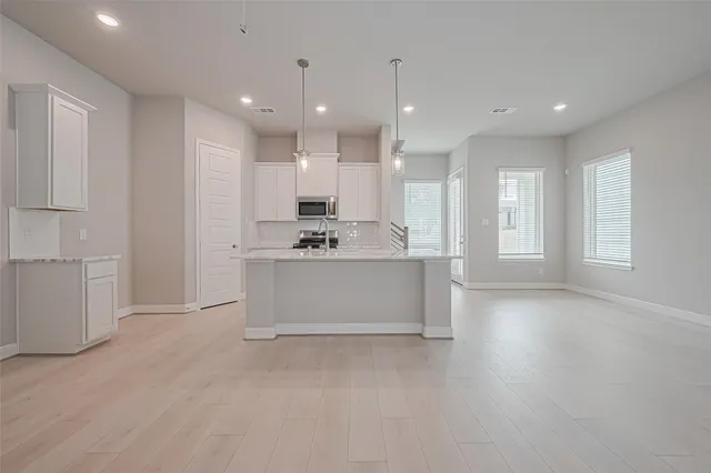 a view of kitchen with kitchen island and stainless steel appliances