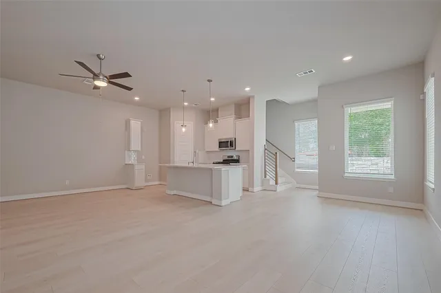 a view of an empty room with a kitchen