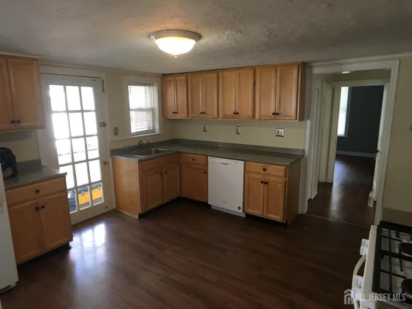 a kitchen with stainless steel appliances granite countertop wooden floors and sink