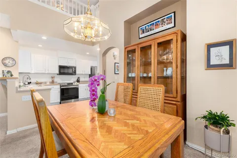 a dining room with stainless steel appliances kitchen island granite countertop a dining table and chairs