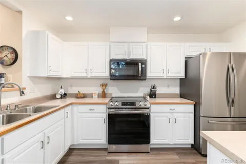 a kitchen with a sink a stove a refrigerator and cabinets
