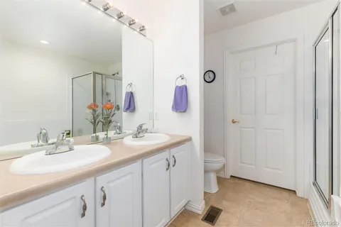 a bathroom with a double vanity sink mirror and toilet