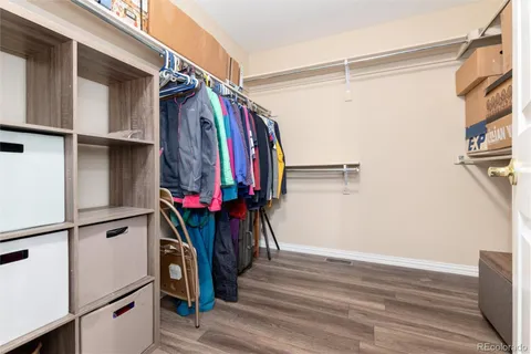 a view of walk in closet with clothes and shoes