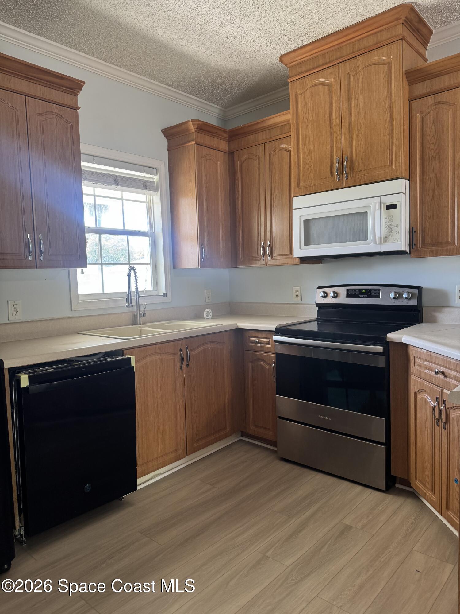 1130 Grapefruit Road Southeast Palm Bay, FL 32909 - Photo 5 of 14 a kitchen with a sink stove and cabinets