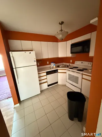 a kitchen with a refrigerator sink and wooden floor