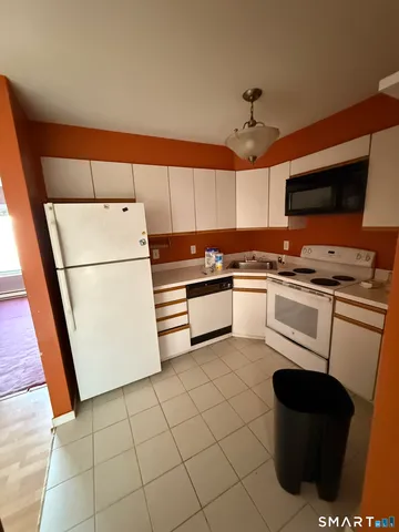 a kitchen with a sink a stove top oven and cabinetry
