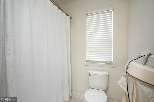 a white toilet sitting next to a white sink