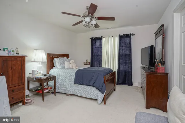 a bedroom with a bed and a flat tv screen on dresser