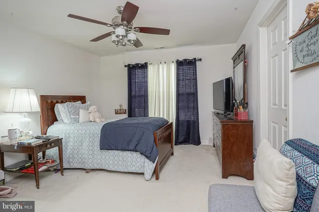 a bedroom with a bed couch and a flat tv screen
