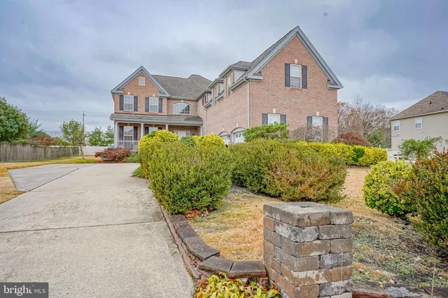 a front view of a house with a yard and potted plants