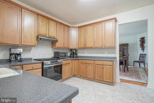 a kitchen with stainless steel appliances granite countertop a stove a sink dishwasher and a refrigerator