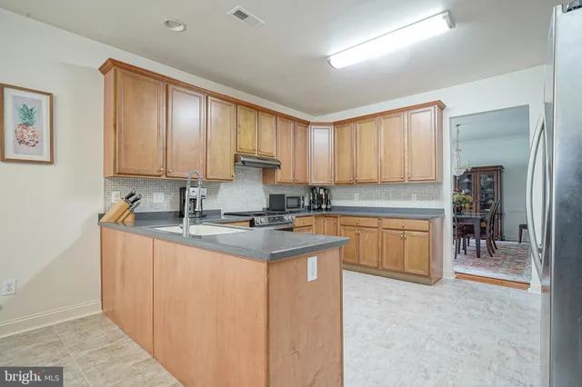 a kitchen with granite countertop a sink stove and cabinets