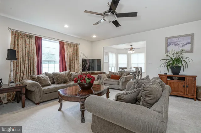 a living room with furniture ceiling fan and a window