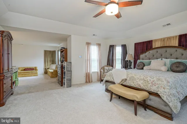 a spacious bedroom with a bed and a chandelier