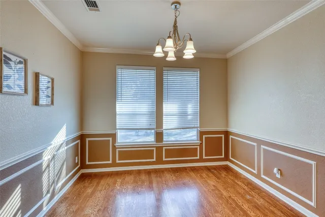 an empty room with a ceiling fan and windows