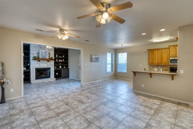 a kitchen with stainless steel appliances granite countertop a stove top oven a sink dishwasher a dining table and chairs with wooden floor