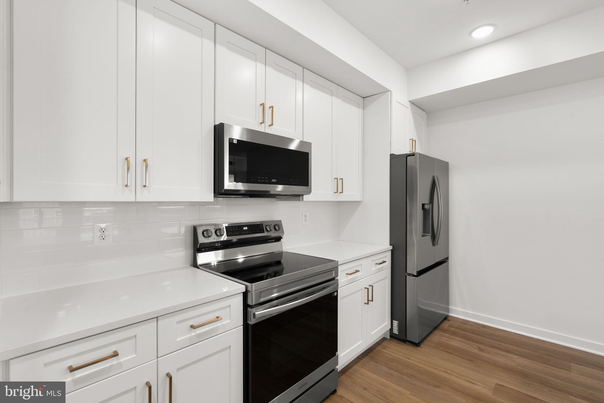 1631 Blacksmith Way, Unit 214B Frederick, MD 21702 - Photo 14 of 41 a kitchen with stainless steel appliances a stove microwave and refrigerator