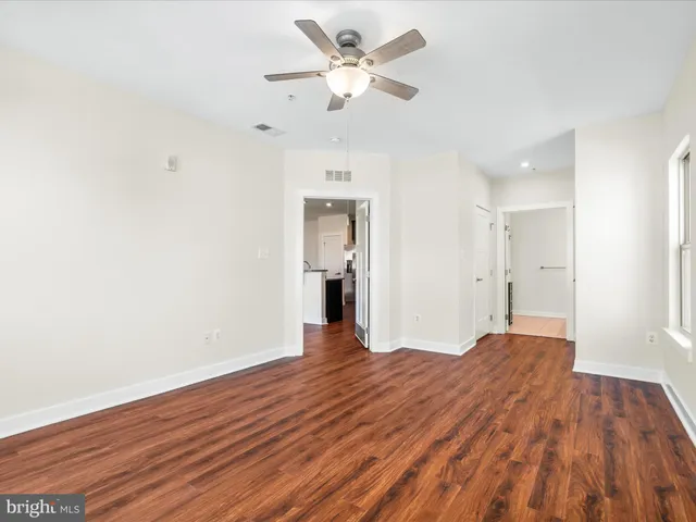 a view of a big room with wooden floor and a chandelier fan