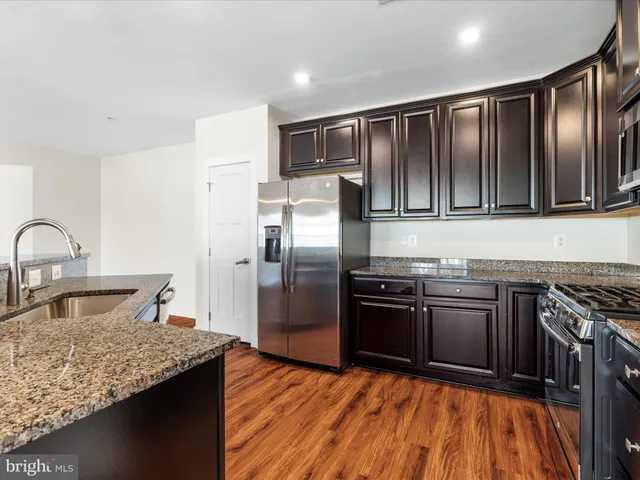 a kitchen with granite countertop stainless steel appliances and wooden cabinets