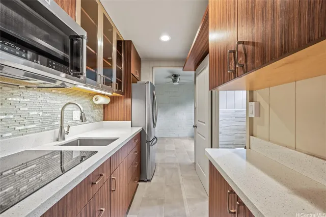 a kitchen with stainless steel appliances granite countertop a sink and a refrigerator