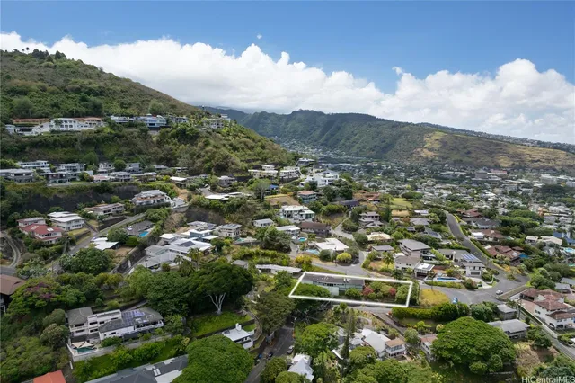 an aerial view of residential houses with outdoor space and trees