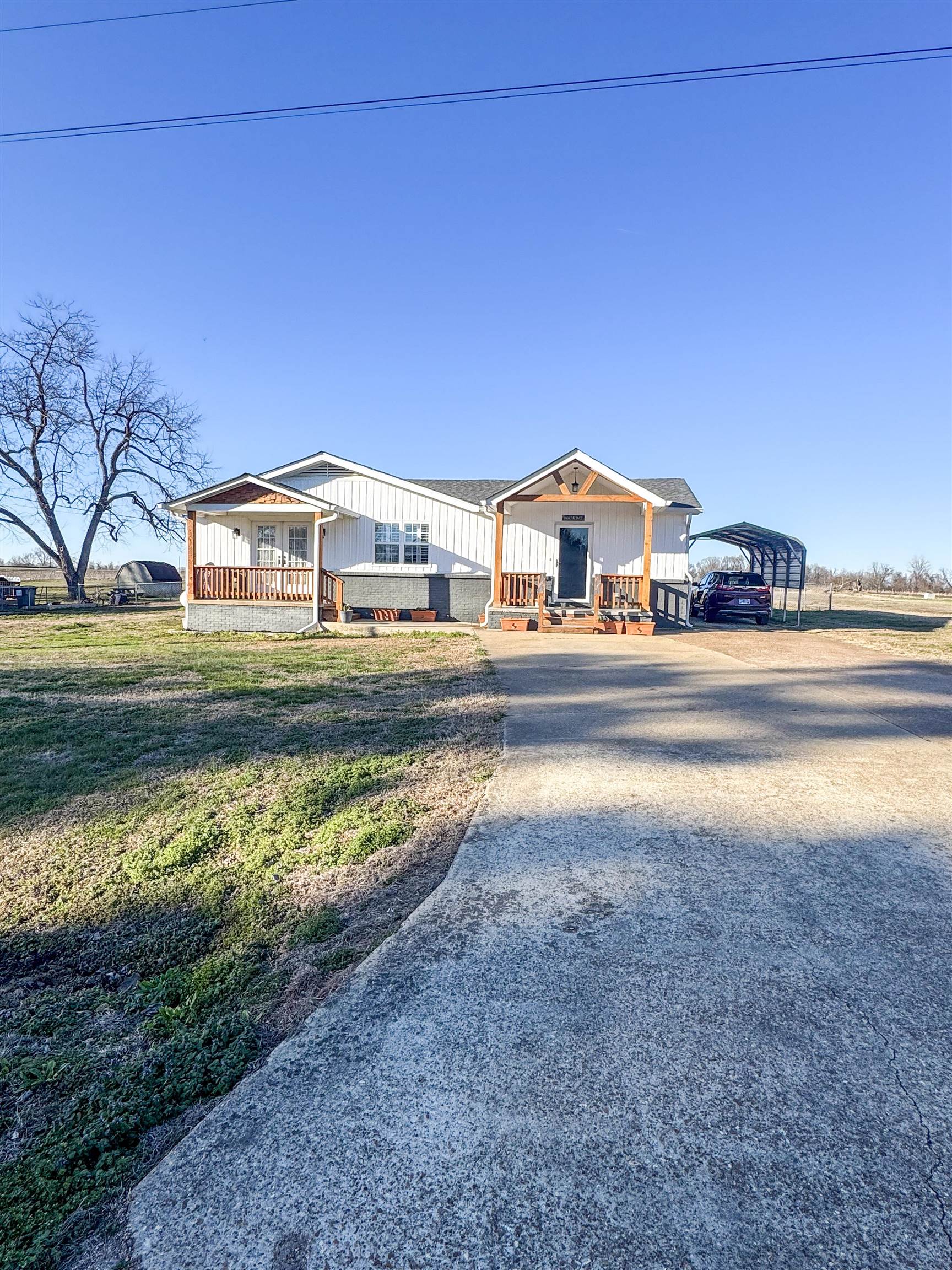 792 Smith Drive Covington, TN 38019 - Photo 2 of 34 View of front of property with a porch, board and batten siding, a carport, driveway, and a front yard