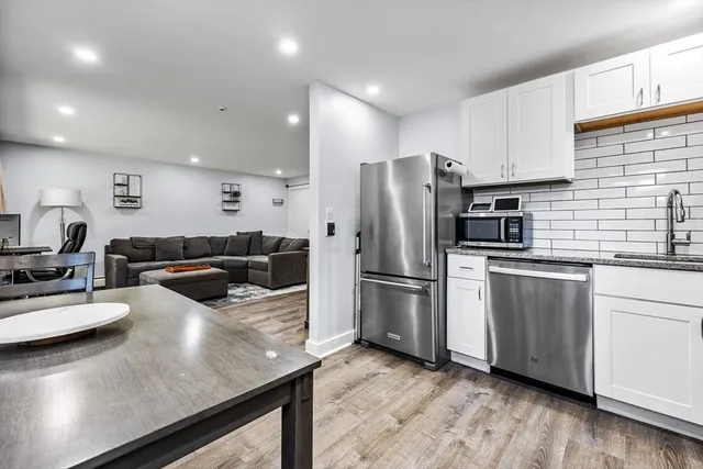a kitchen with a refrigerator a stove a sink and white cabinets