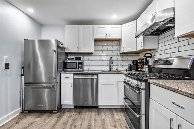 a kitchen with stainless steel appliances granite countertop a refrigerator sink and microwave