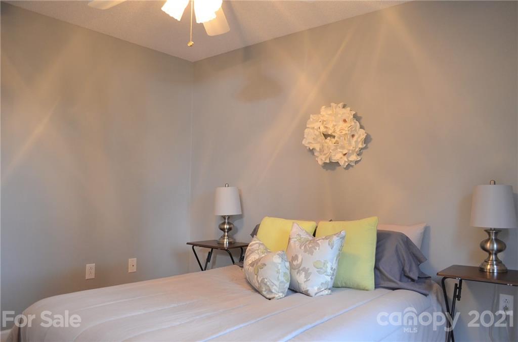 7610 Sarah Drive Denver, NC 28037 - Photo 22 of 48 a bedroom with a bed and a chandelier
