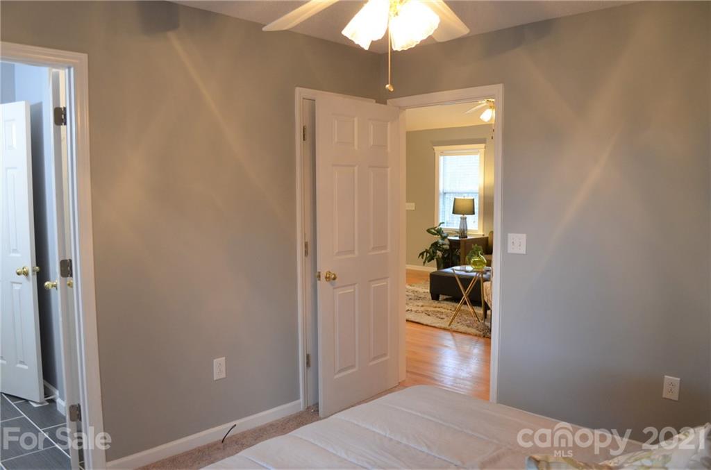 7610 Sarah Drive Denver, NC 28037 - Photo 23 of 48 a bedroom with a bed and a chandelier fan