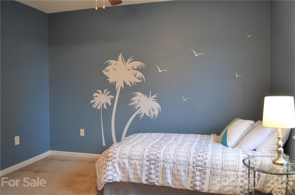 7610 Sarah Drive Denver, NC 28037 - Photo 32 of 48 a bedroom with a bed and a chandelier